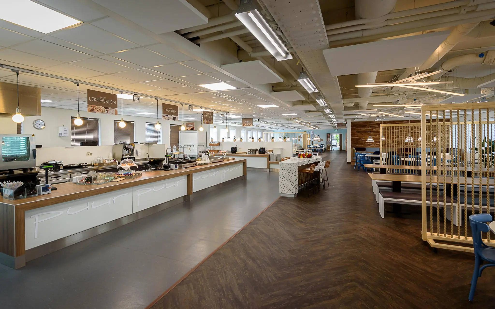 Moderne bedrijfskantine aan het Rivium Boulevard met zelfbedieningsbuffet en zitgedeelte.